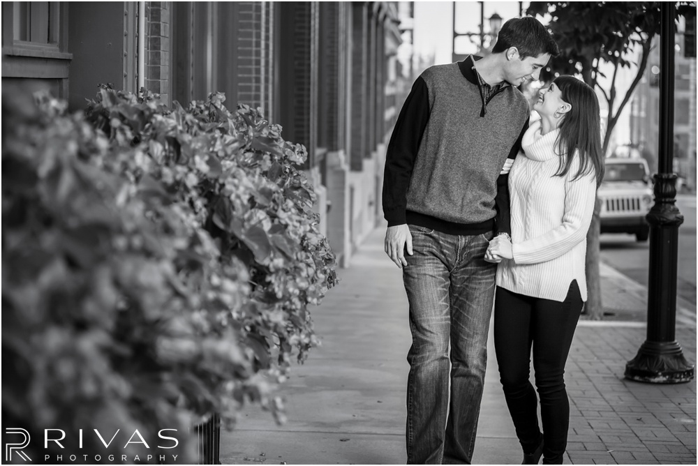 Timeless Garment District Engagement Session | A photo of an engaged couple in fall sweaters walking down a street in downtown Kansas City. 