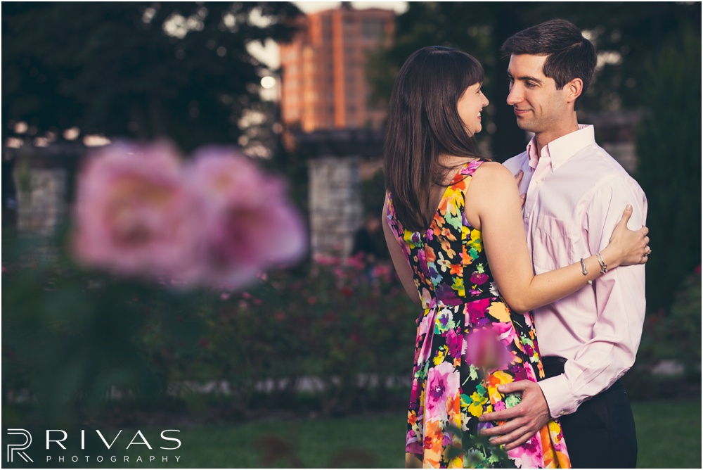 Timeless Garment District Engagement Session | A photo of an engaged couple hugging in the rose garden at Loose Park. 