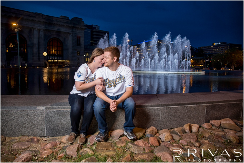 Colorful Fall Engagement Session |  An image of an engaged couple embracing in front of the fountain outside Kansas City's Union Station at dusk. 