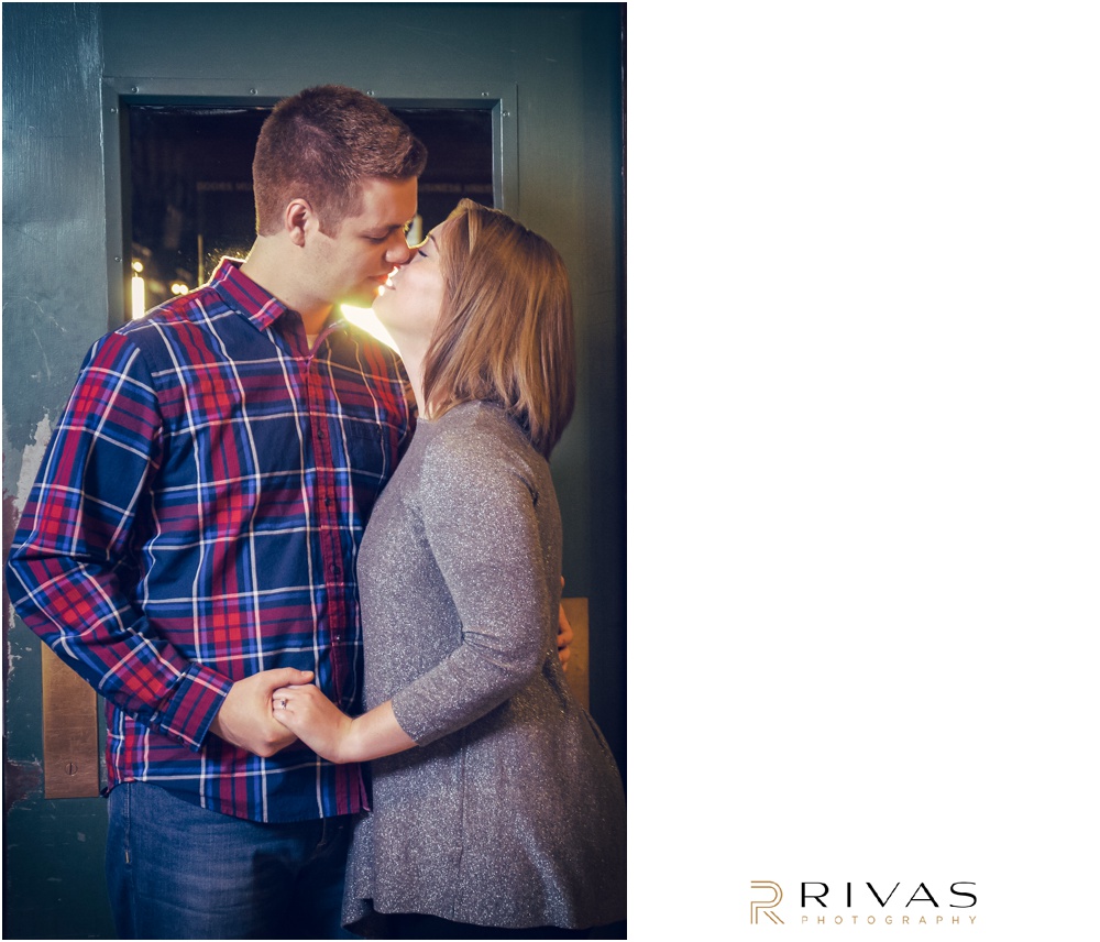 Colorful Fall Engagement Session |  A picture of an engaged couple sharing a kiss in front of a green door at Union Station. 
