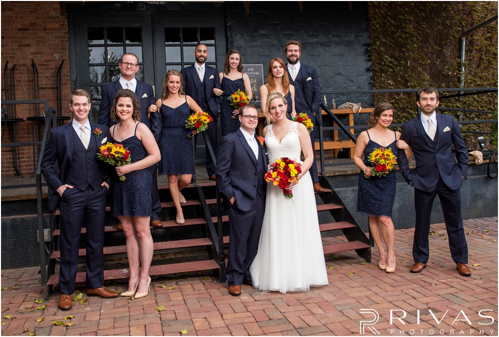 Rustic Outdoor Fall Wedding | A bride and groom with their wedding party on the stairs of Feasts of Fancy. 