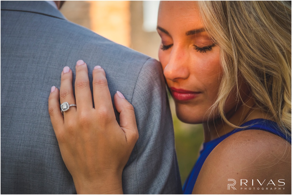 romantic castle ruins engagement pictures | An image of a bride peeking over a groom's shoulder. 