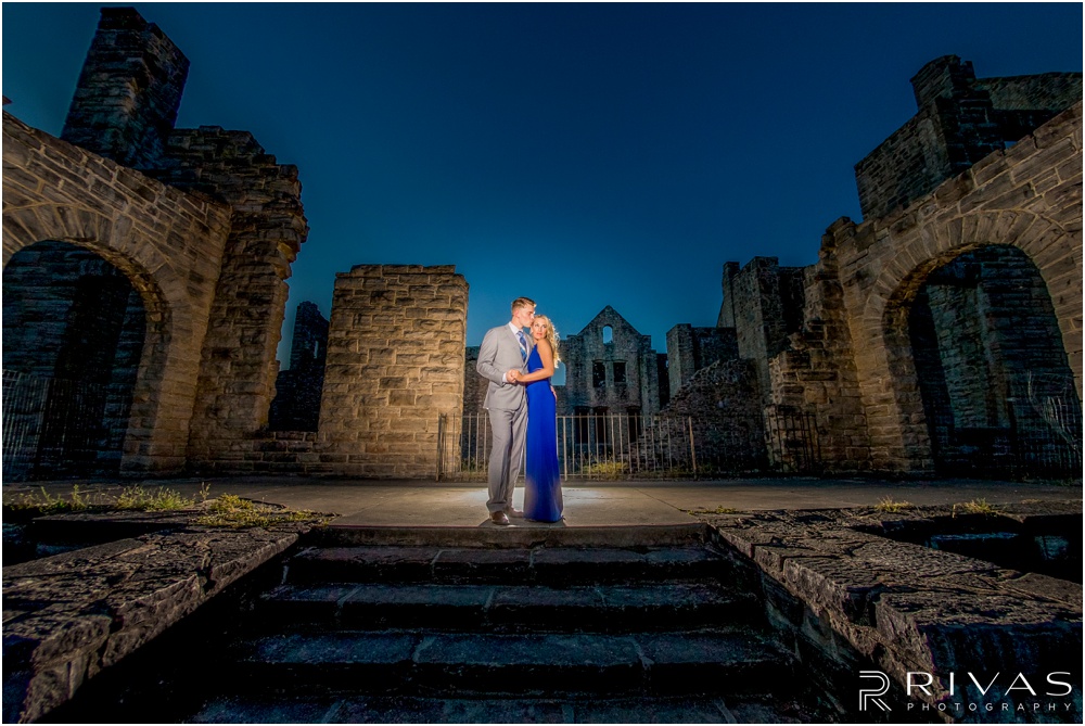 romantic castle ruins engagement pictures | A picture of an engaged couple embracing on stairs leading to castle ruins. 