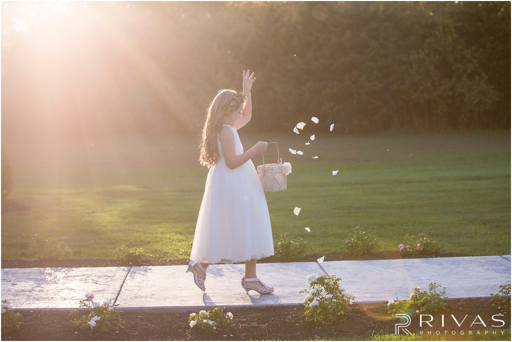elegant fall wedding buffalo lodge | A picture of a flower girl tossing rose petals as she walks down the aisle at The Buffalo Lodge. 