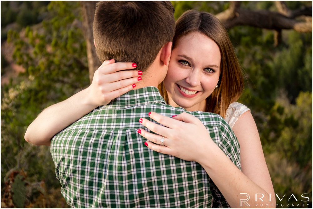 Merry-Go-Round Rock Engagement Session | Picture of a bride peeking over her groom's shoulder at Merry-Go-Round Rock in Sedona. 