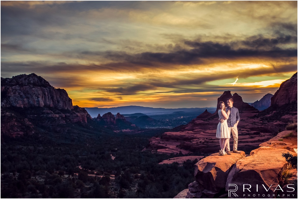 Merry-Go-Round Rock Engagement Session | Picture of an engaged couple standing on Merry-Go-Round Rock at sunset in Sedona.  