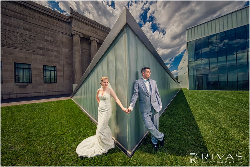 Wedding Day Sneak Peek | Photo of a bride and groom holding hands in front of the Bloch Building at The Nelson Atkins Museum of Art in Kansas City. 