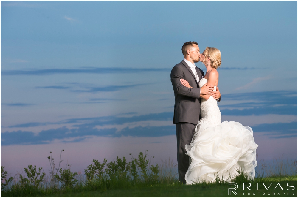 Staley Farms Golf Club Summer Wedding | A sunset portrait of a bride and groom sharing a kiss taken during their wedding reception held at Staley Farms Golf Club in Kansas City. 