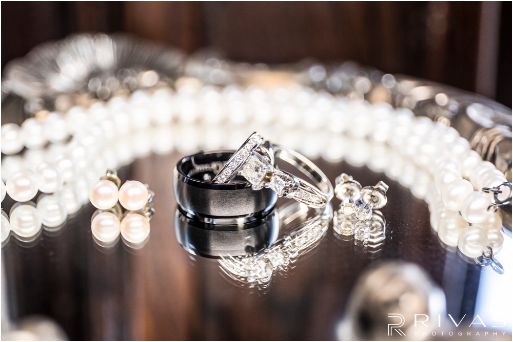Classic Summer Wedding at Berg Event Space | A close-up detailed photo of a bride's pearls, earrings, and wedding bands placed on a mirror. 