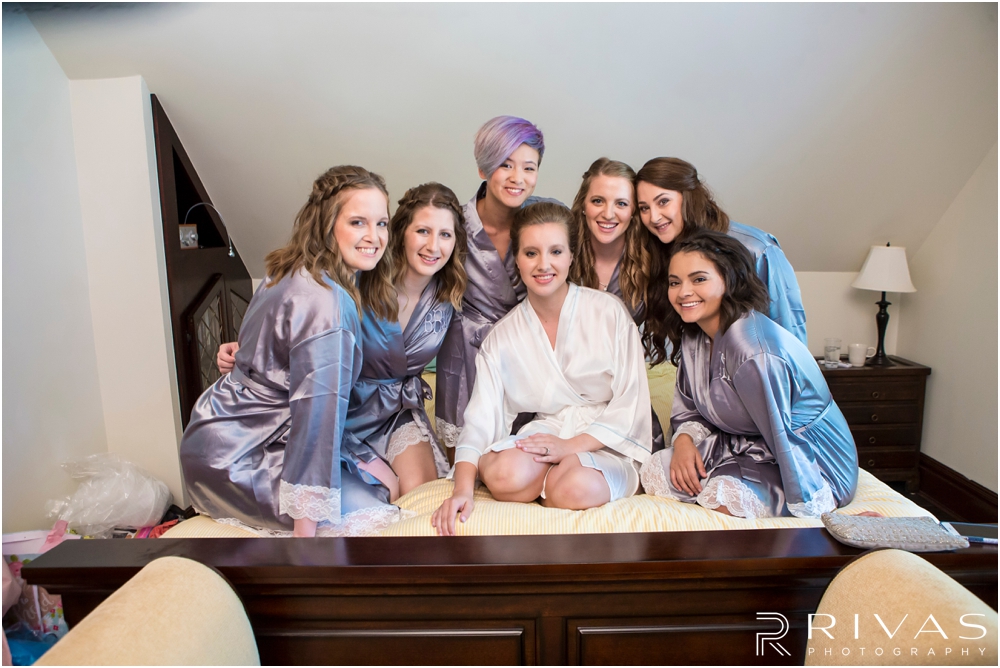 Classic Summer Wedding at Berg Event Space | A candid image of a bride and her bridesmaids in matching wedding day robes. 