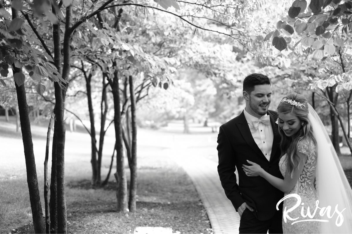Elegant KC Wedding Sneak Peek | Kansas City Wedding Photographers | A black and white photo of a bride and groom embracing and laughing on their wedding day at Kansas City's Nelson Atkins Museum of Art. 