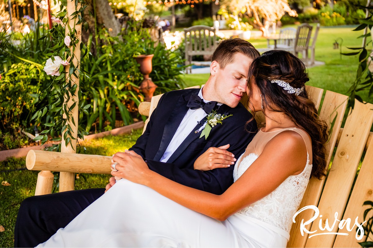 8 Things Your Wedding Photographer Wants you to Know | An intimate, candid photo of a bride and groom snuggled up on a wooden swing on the evening of their wedding at Saddlerock Ranch in Malibu, California. 