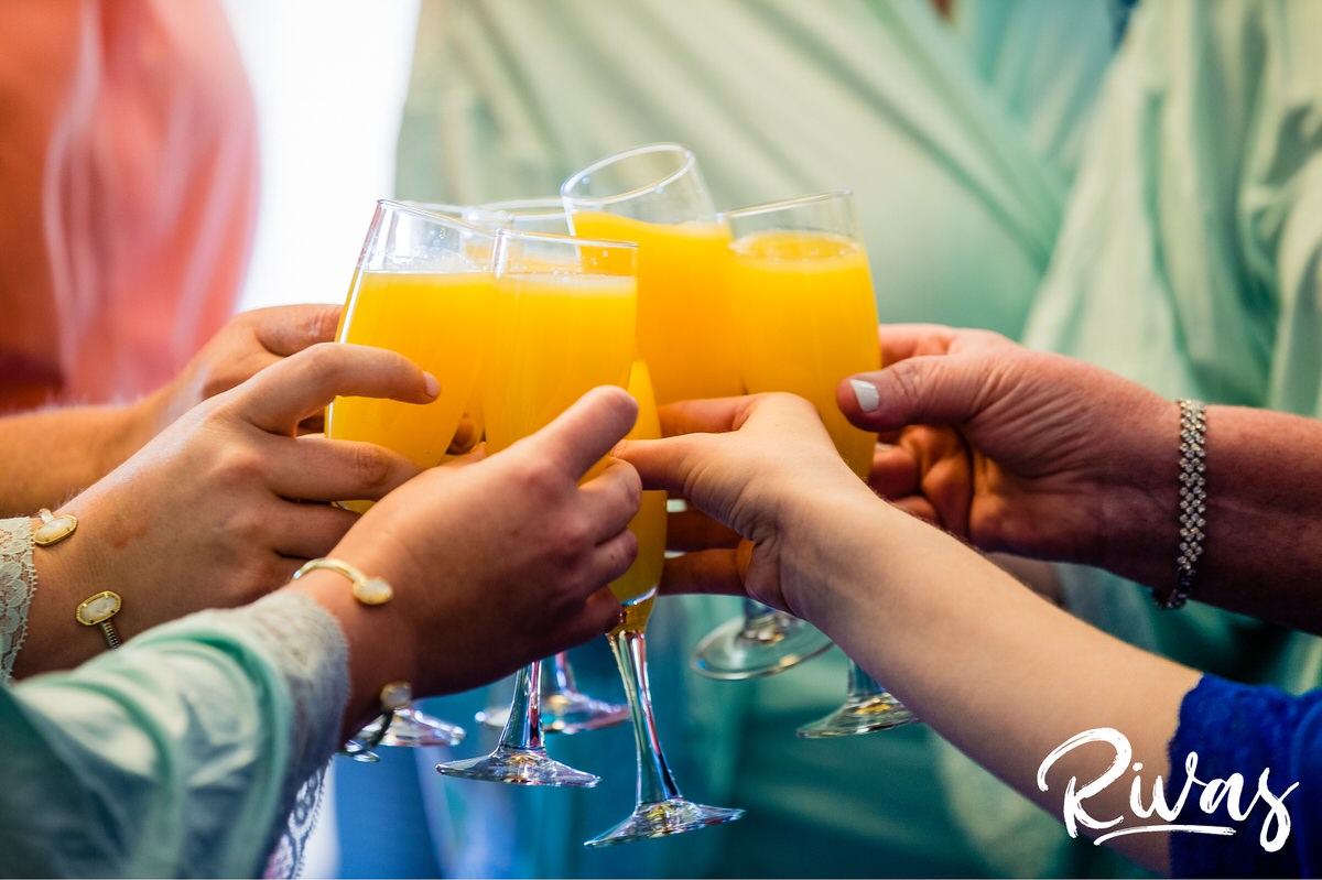 Strawberry Hill Summer Wedding | Rivas Photography | Kansas City Wedding Pictures | A close-up photo of a bride, her bridesmaids and moms making a mimosa toast on the morning of her Kansas City Wedding. 