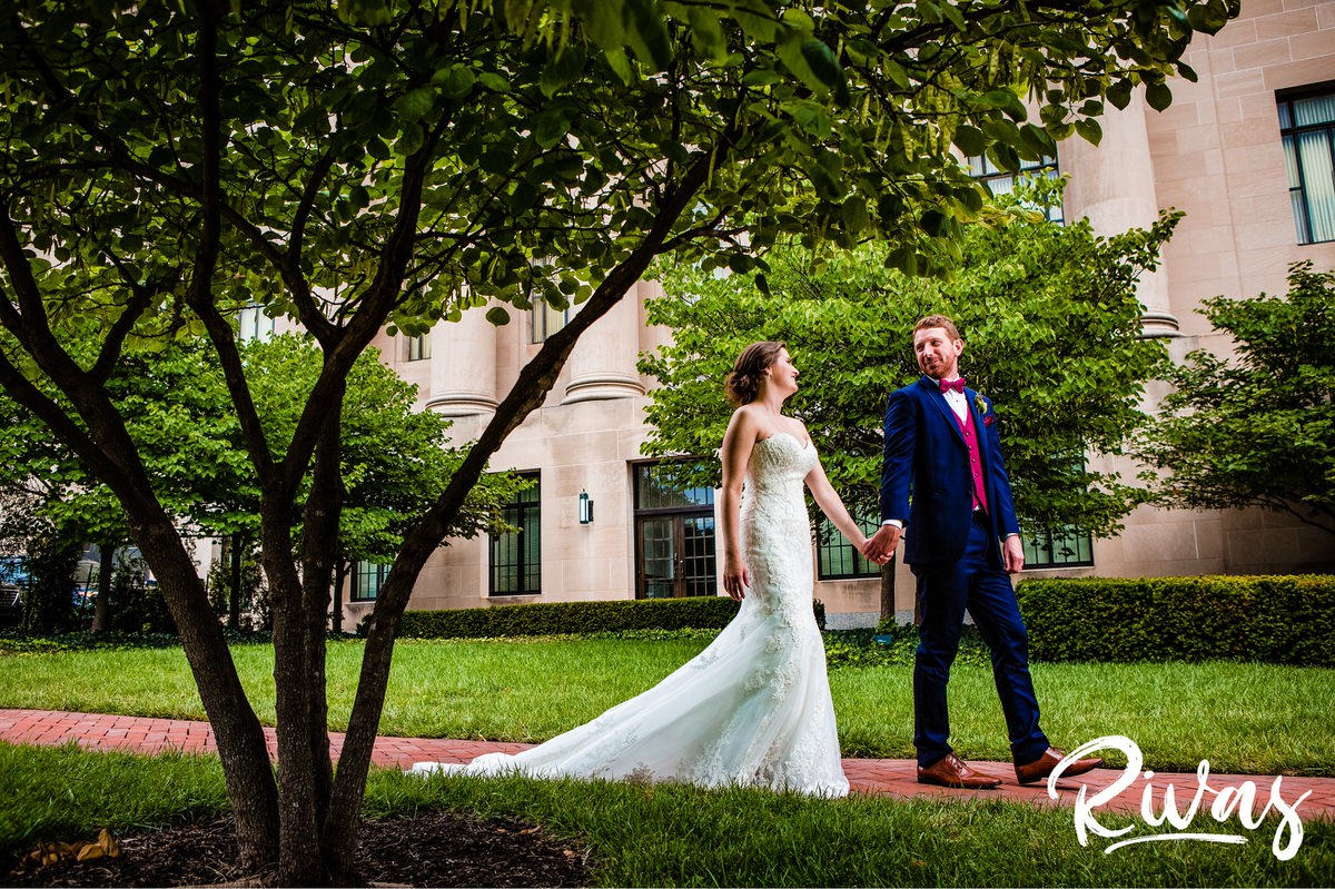Strawberry Hill Summer Wedding | Rivas Photography | Kansas City Wedding Pictures | A vibrant picture of a bride and groom walking hand in hand on their wedding day at Kansas City's Nelson Atkins Museum of Art. 