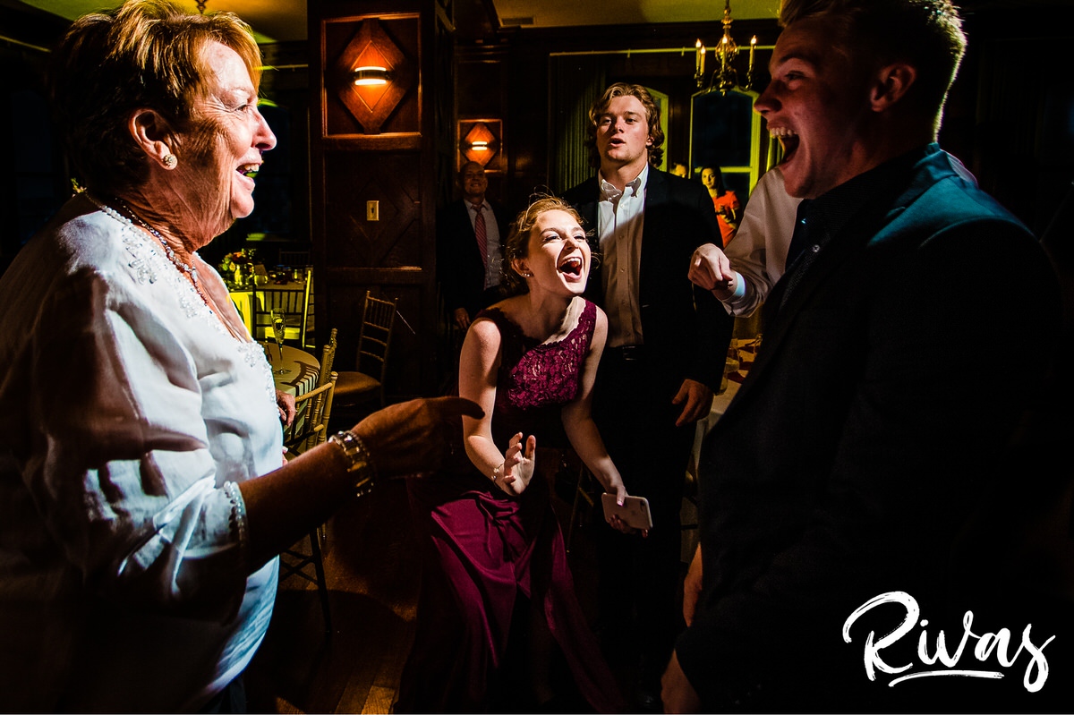 Strawberry Hill Summer Wedding | Rivas Photography | Kansas City Wedding Pictures | A candid photo taken during a wedding reception held in The Tudor Room at Kansas City's Brass on Baltimore of a bridesmaid excitedly singing and dancing on the dance floor. 
