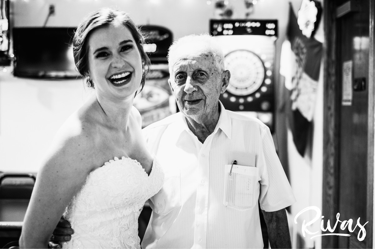 Strawberry Hill Summer Wedding | Rivas Photography | Kansas City Wedding Pictures | A black and white photo of a bride and her grandfather's friend sharing an embrace on her wedding day in Kansas City. 
