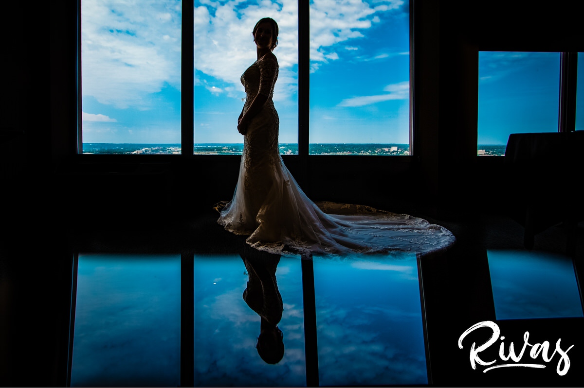 Strawberry Hill Summer Wedding | Rivas Photography | Kansas City Wedding Pictures | A vibrant photo of a bride and her reflection just after she's finished getting dressed on the morning of her Kansas City wedding with a blue sky in the background. 