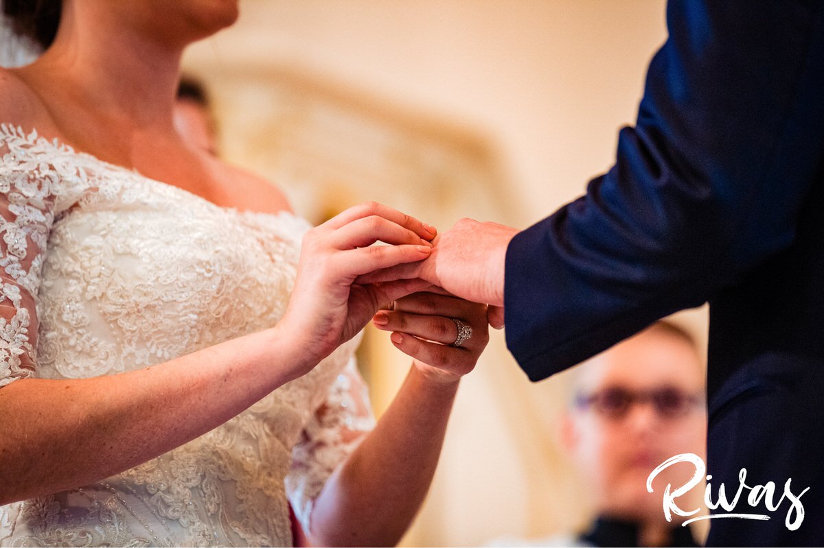 Strawberry Hill Summer Wedding | Rivas Photography | Kansas City Wedding Pictures | An up-close, detailed image of a bride putting a wedding band on her groom's finger during their wedding ceremony in Kansas City. 