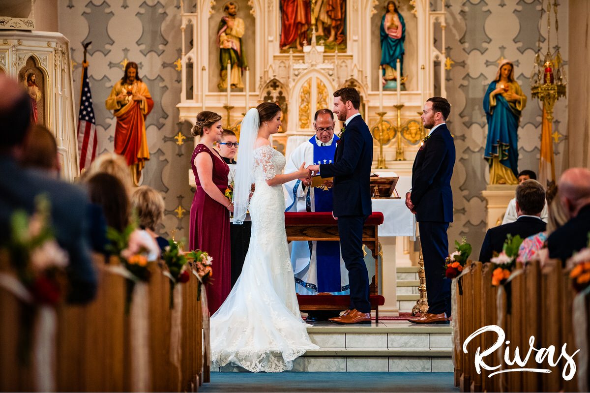Strawberry Hill Summer Wedding | Rivas Photography | Kansas City Wedding Pictures | A colorful photo taken from the back of the church of a bride and groom exchanging vows on their wedding day in Kansas City. 