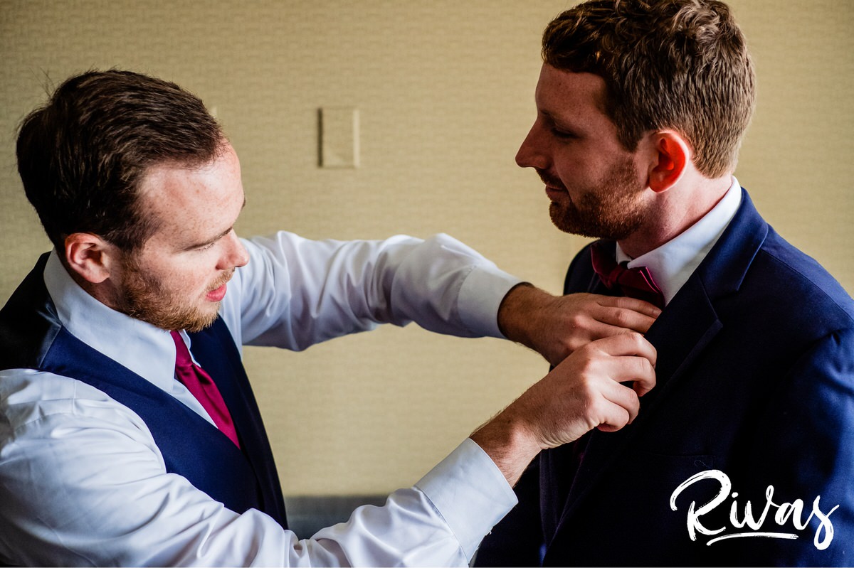 Strawberry Hill Summer Wedding | Rivas Photography | Kansas City Wedding Pictures | A candid picture of a groom's best man straightening his tie and collar on the morning of his wedding day in Kansas City. 