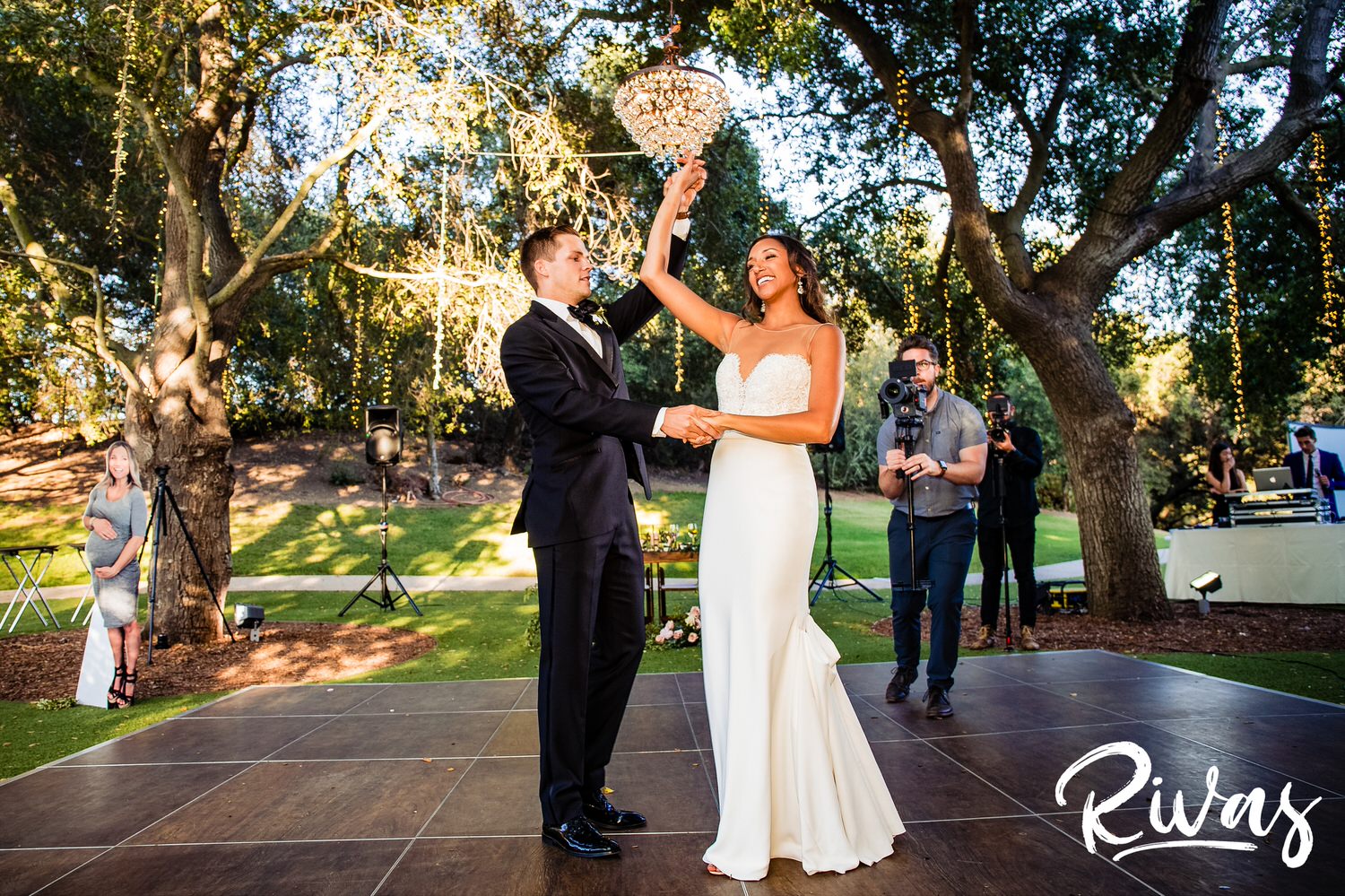 Saddlerock Ranch Summer Wedding | Destination Wedding Photographers | Rivas | A candid picture of a groom twirling his bride as they share their first dance on the dance floor of the wedding reception at Malibu's Saddlerock Ranch. 