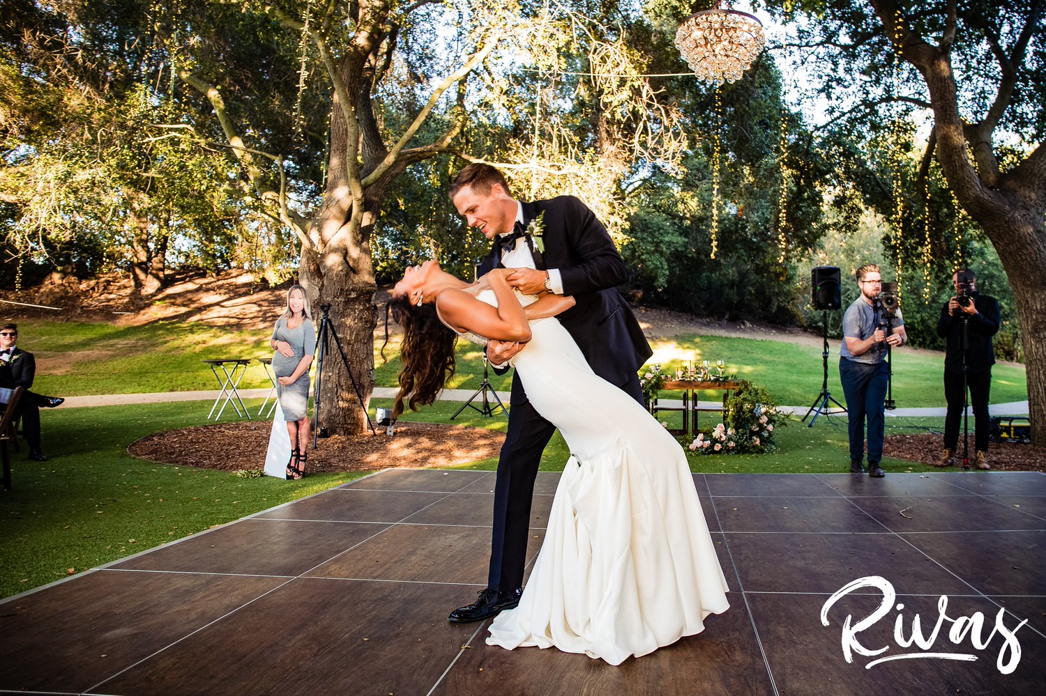 Saddlerock Ranch Summer Wedding | Destination Wedding Photographers | Rivas | A photo of a bride and groom laughing as he dips his bride on the dance floor of their Saddlerock Ranch wedding reception. 