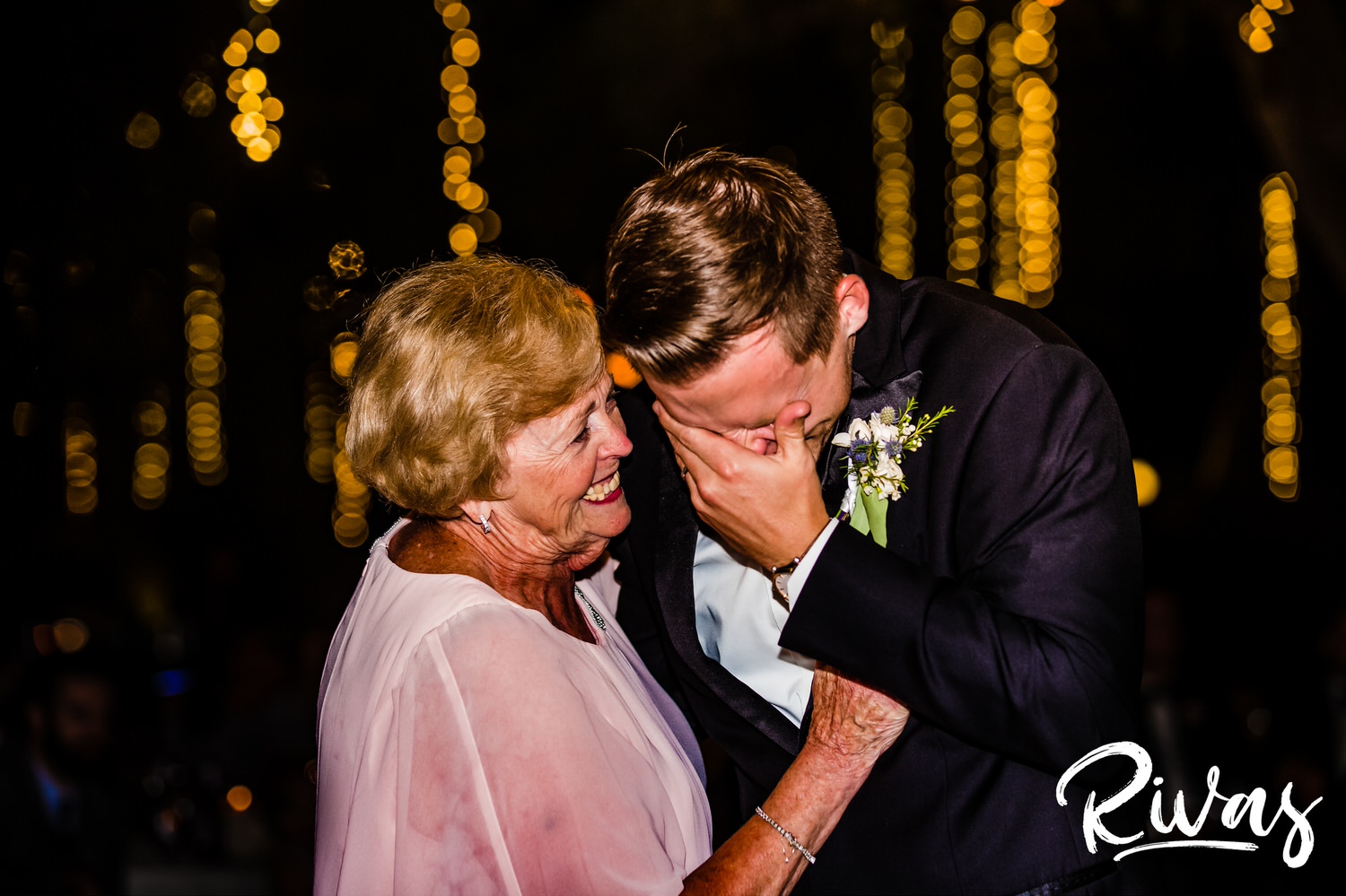 Saddlerock Ranch Summer Wedding | Destination Wedding Photographers | Rivas | An intimate photo of a groom dancing with his grandmother underneath a sea of ropes of twinkly lights during his wedding reception at Saddlerock Ranch in Malibu. 