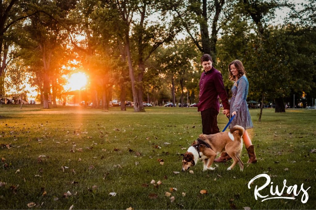 West Bottoms Engagement Pictures | A candid photo of an engaged couple walking their dog through English Landing Park at sunset. 