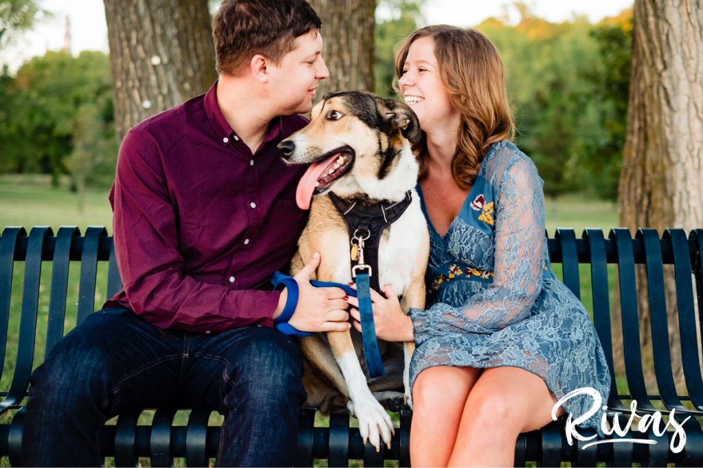 West Bottoms Engagement Pictures | A candid picture of an engaged couple and their dog sitting on a park bench laughing together during their engagement session. 