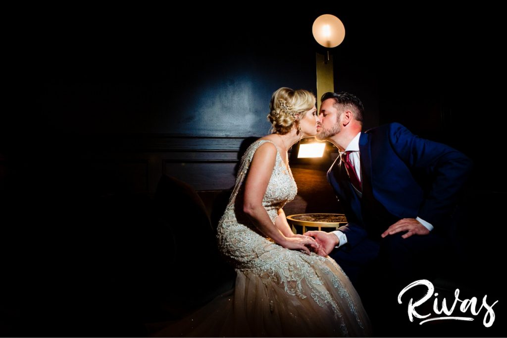 Art Deco Inspired Wedding in Kansas City | An intimate picture of a bride and groom leaning over a table to share a kiss at Hotel Phillips in Kansas City. 