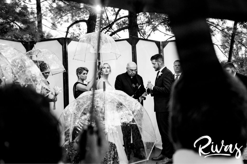 Art Deco Inspired Wedding in Kansas City | a black and white picture of a bride looking up at the rainy sky during her outside wedding ceremony at Californos in Westport. 