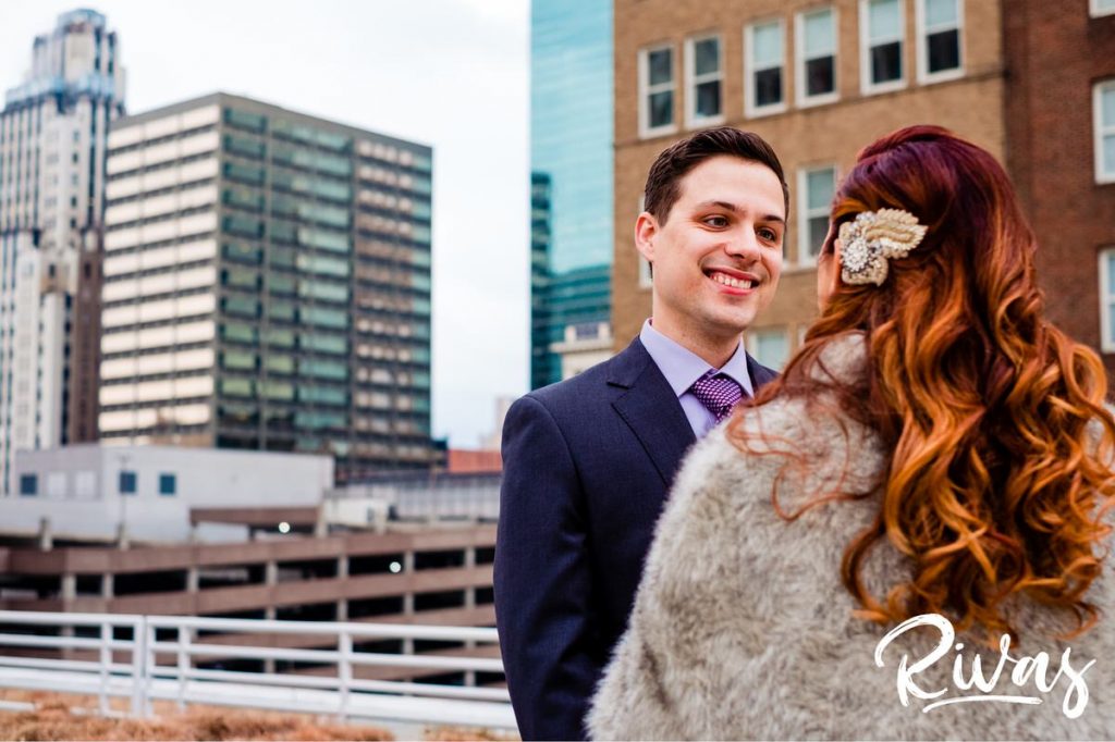 Downtown KC Library Wedding | A candid picture of a bride and groom sharing their first look together on the rooftop of the Kansas City downtown public library.