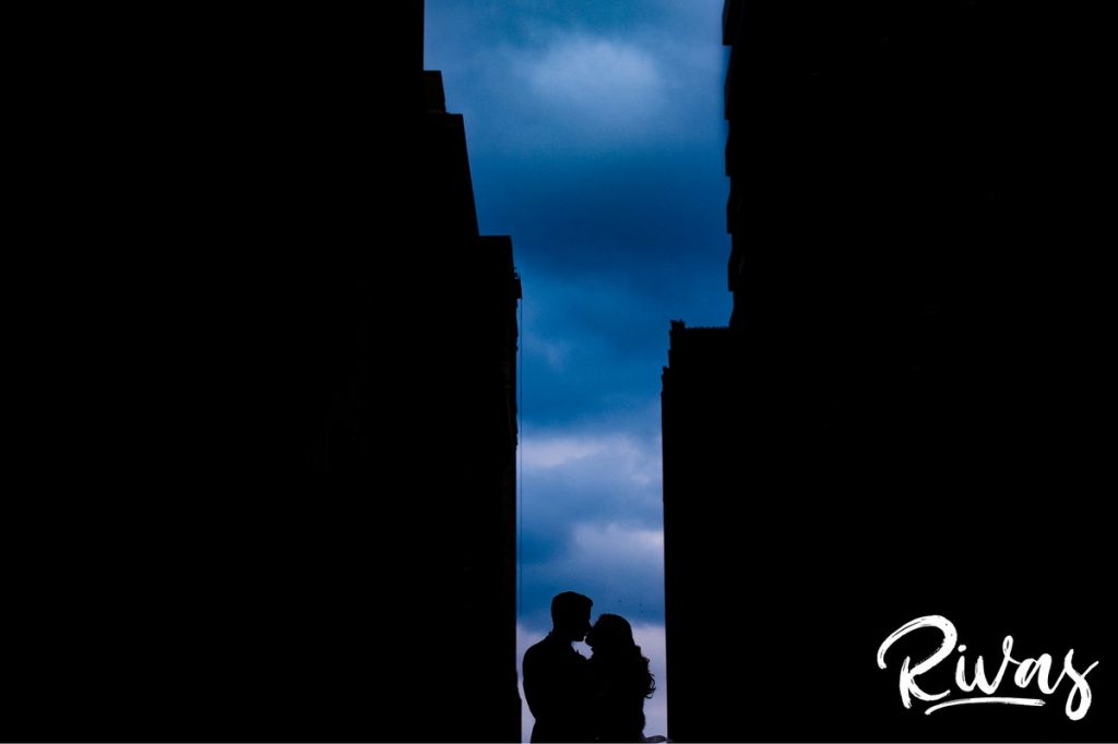 Downtown KC Library Wedding | A silhouette of a bride and groom standing in between two tall buildings on the roof of the downtown public library in Kansas City.