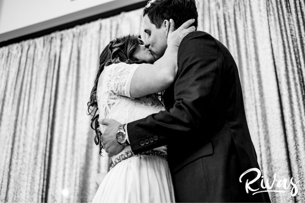Downtown KC Library Wedding | A close-up, black and white picture of a bride and groom sharing their first kiss during their wedding ceremony at the downtown public library in Kansas City.