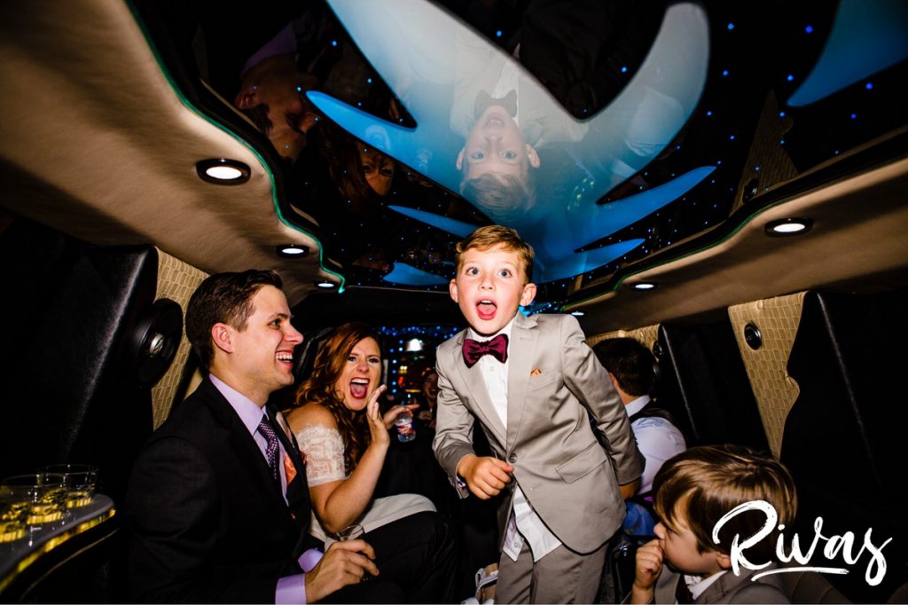Downtown KC Library Wedding - Rivas Photography  | A candid picture of a ring bearer doing the floss dance in the back of a crowded limo. 