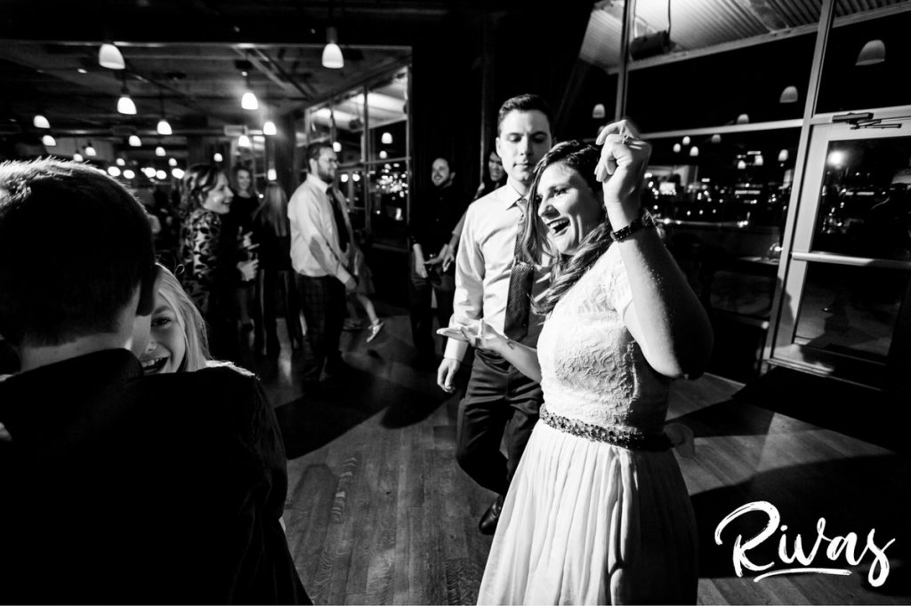 Downtown KC Library Wedding - Rivas Photography  | A candid black and white picture of a bride and groom dancing together during their wedding reception. 