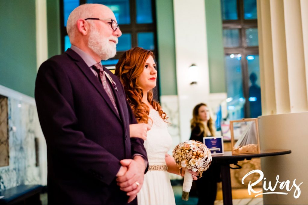 Downtown KC Library Wedding | A candid picture of a bride and her father taking a deep breath as they start to walk down the aisle together on her wedding day at the downtown Kansas City Public Library.