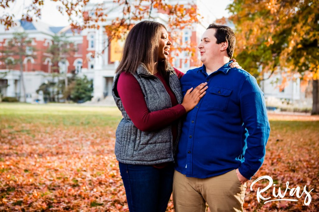 Fall MU Engagement Session | A candid picture of an engaged couple standing in a colorful yard of leaves during their engagement session in Columbia at MU.