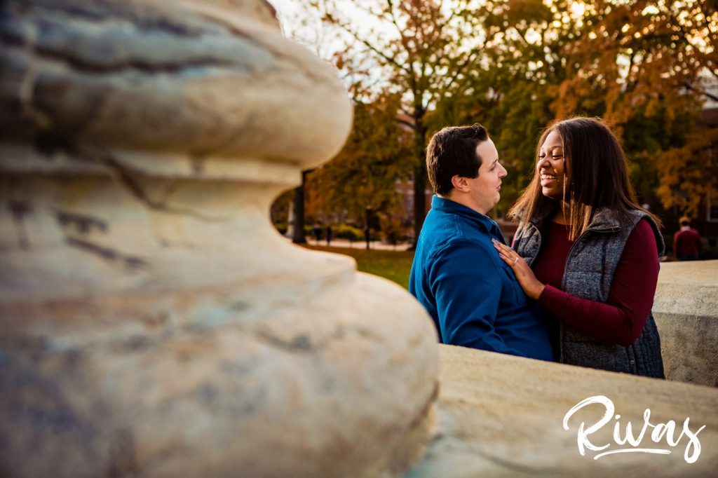 Fall MU Engagement Session | A candid picture of an engaged couple sharing an embrace while learning up against the MU columns.