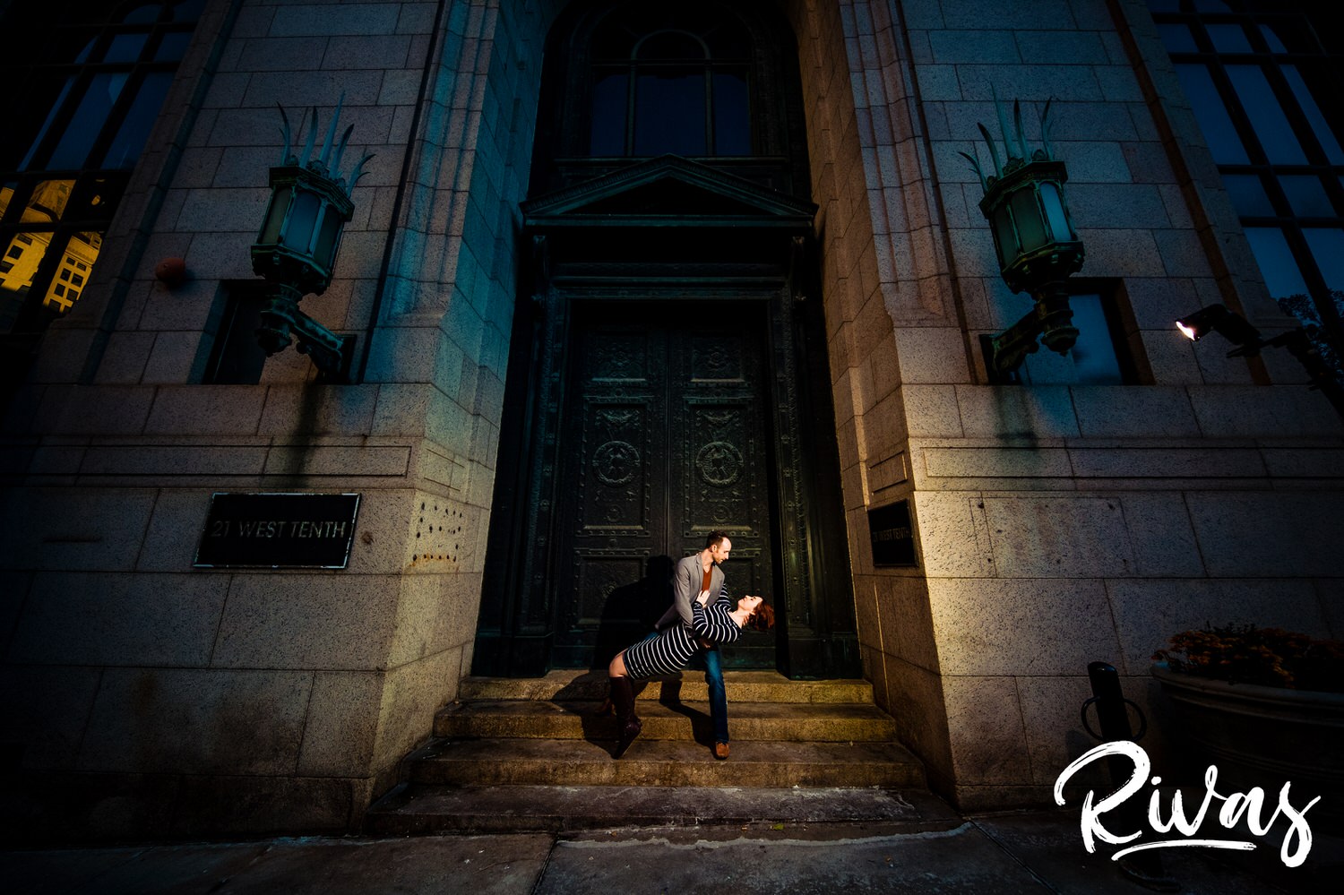 A dramatic portrait of a man dipping a woman back on the stairs of the New England Bank in downtown Kansas City during their engagement session. 