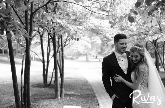 Elegant KC Wedding Sneak Peek | Kansas City Wedding Photographers | A black and white photo of a bride and groom embracing and laughing on their wedding day at Kansas City's Nelson Atkins Museum of Art.