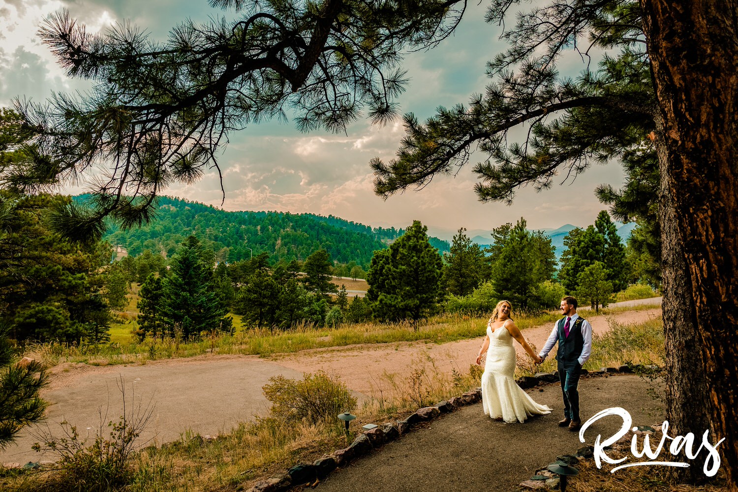 Chief Hosa Lodge Wedding Sneak Peek | Wedding couple walks holding hands down a path in the mountains