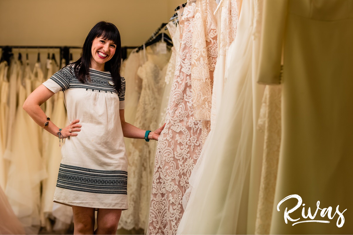 Featured Vendor: Altar Bridal | A candid picture of store manager Sara standing amongst racks of fresh wedding gowns.