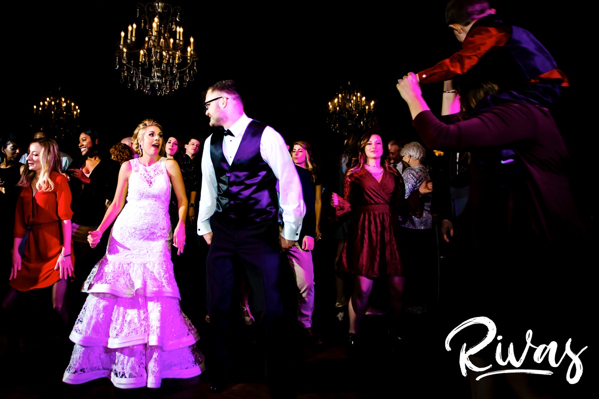 A vibrant picture of a bride and groom in the middle of the dance floor of their wedding reception, surrounded by friends and family at The Stanley. 