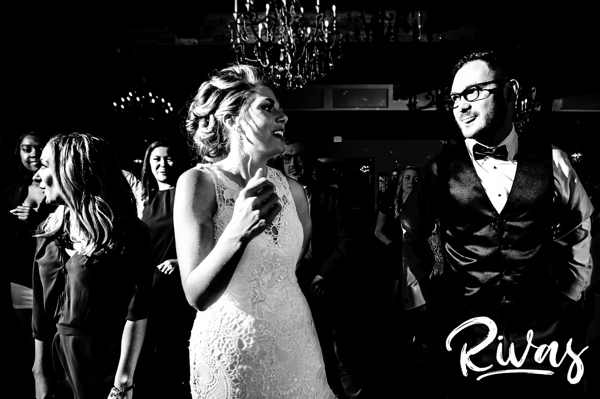 A candid picture of a bride and groom dancing in the middle of the dance floor with their friends and family during their wedding reception at The Stanley in Lee's summit. 