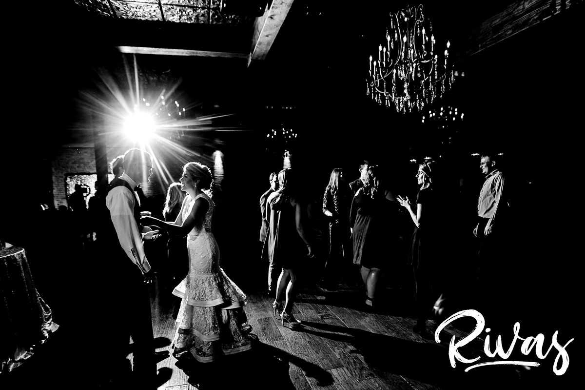 A candid picture of a bride and groom dancing in the middle of the dance floor with their friends and family during their wedding reception at The Stanley in Lee's summit. 