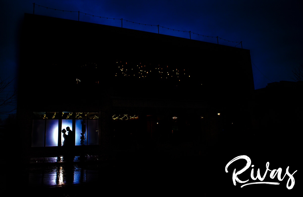 A picture of a couple silhouetted in the windows of The Stanley Event Space on their winter wedding day. 