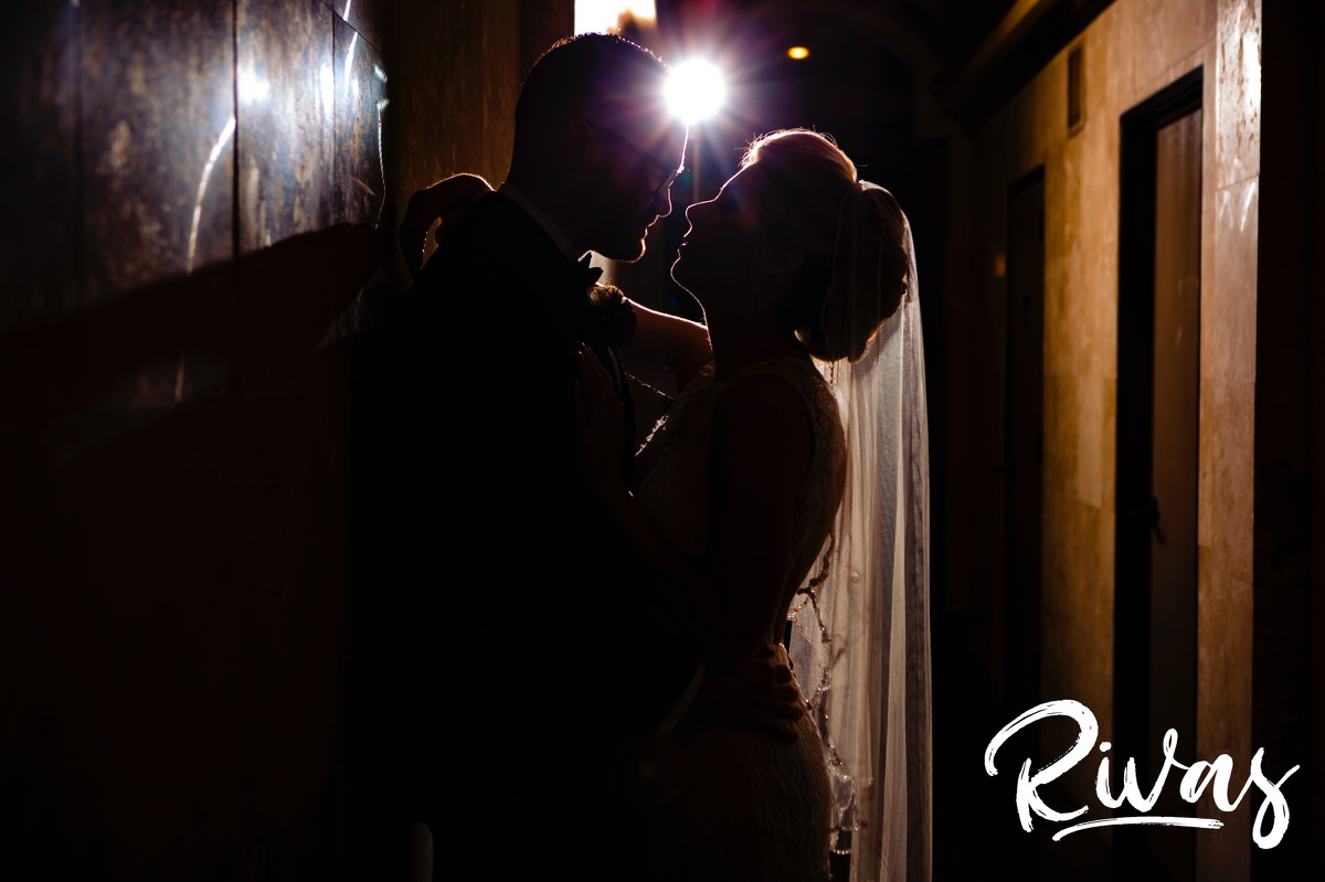 A silhouetted picture of a bride and groom leaning up against the wall in the entry hall of The Stanley in downtown Lee's Summit on the day of their winter wedding. 
