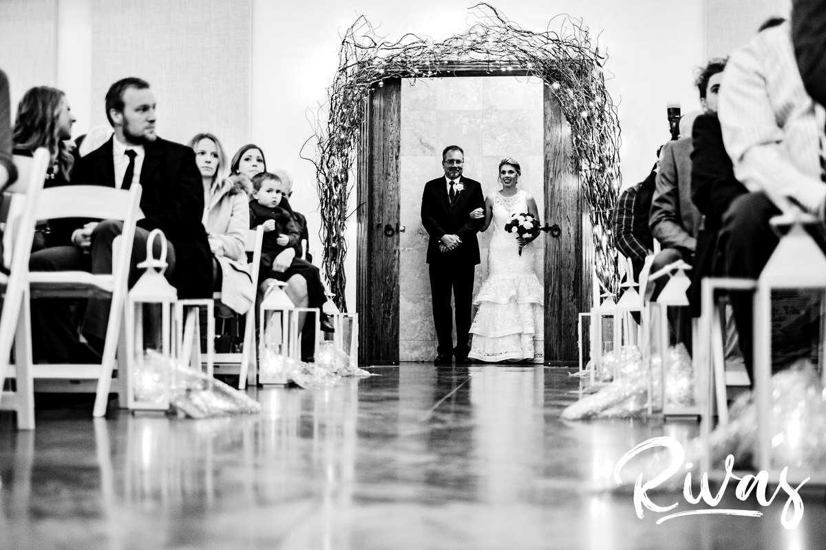 A black and white picture of a bride and her dad at the entry of the aisle of her winter wedding at The Stanley. 