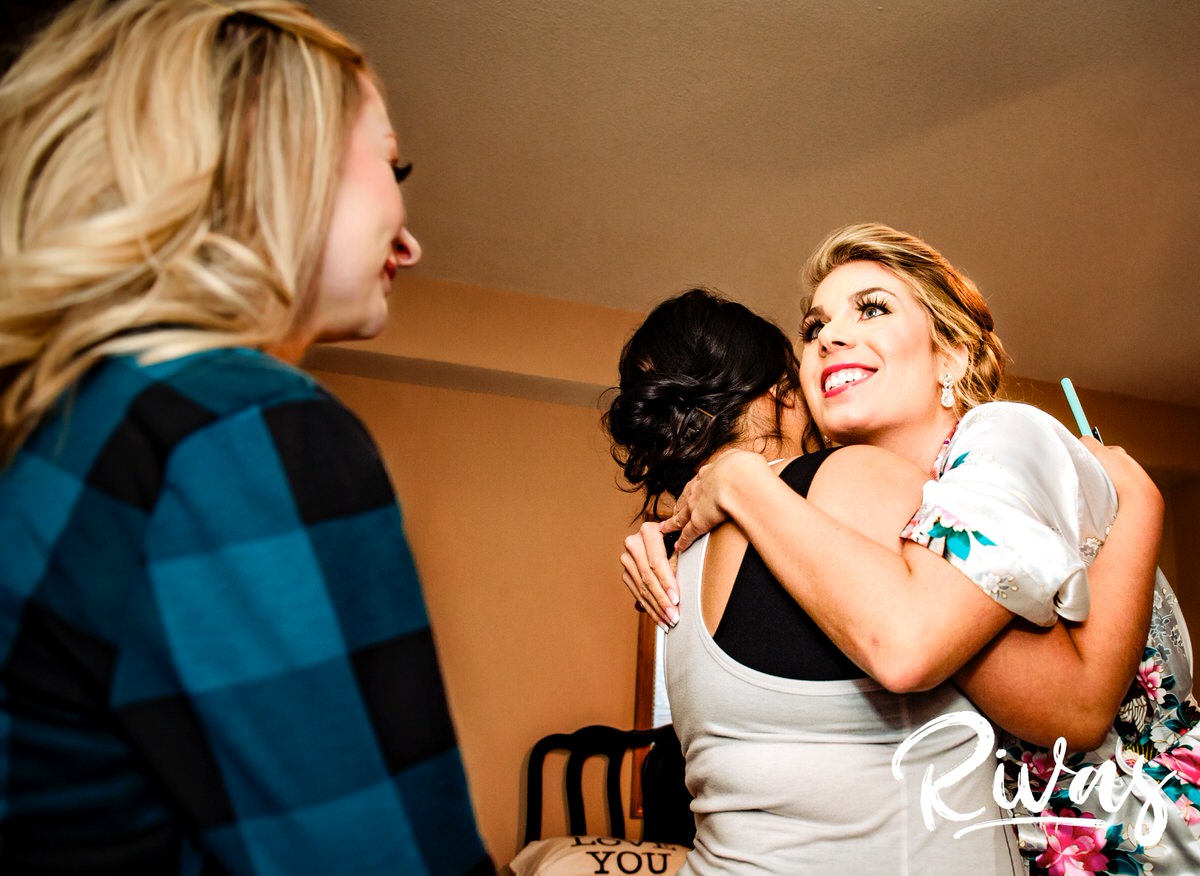 A candid picture of a bride hugging her two best friends after her make-up has been finished on the morning of her winter wedding in Lee's Summit. 